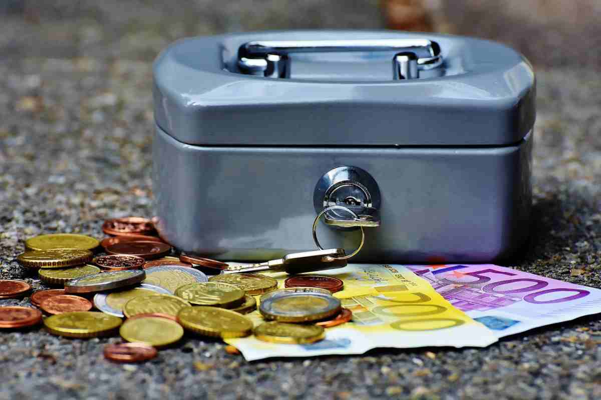 Cassetta di sicurezza e denaro contante poggiati su tavolo