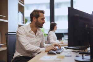 Uomo perplesso mentre lavora al PC