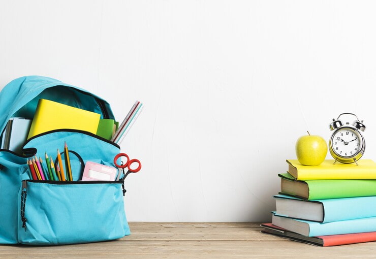 Zaino e libri poggiati su una scrivania