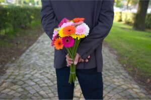 Uomo con mazzo fiori dietro la schiena
